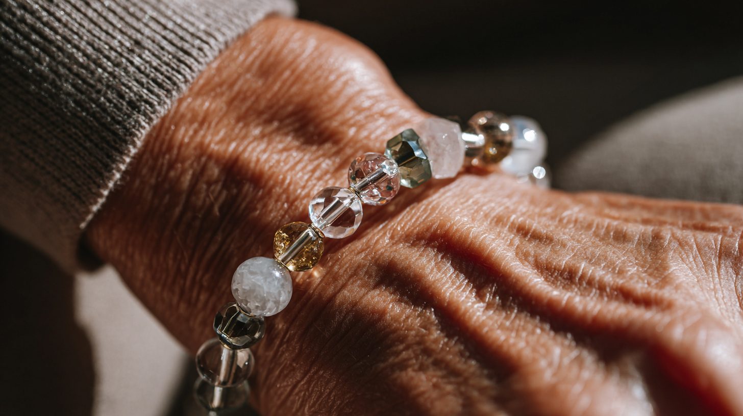 Close-up of a hand wearing a bracelet with clear and gold beads.