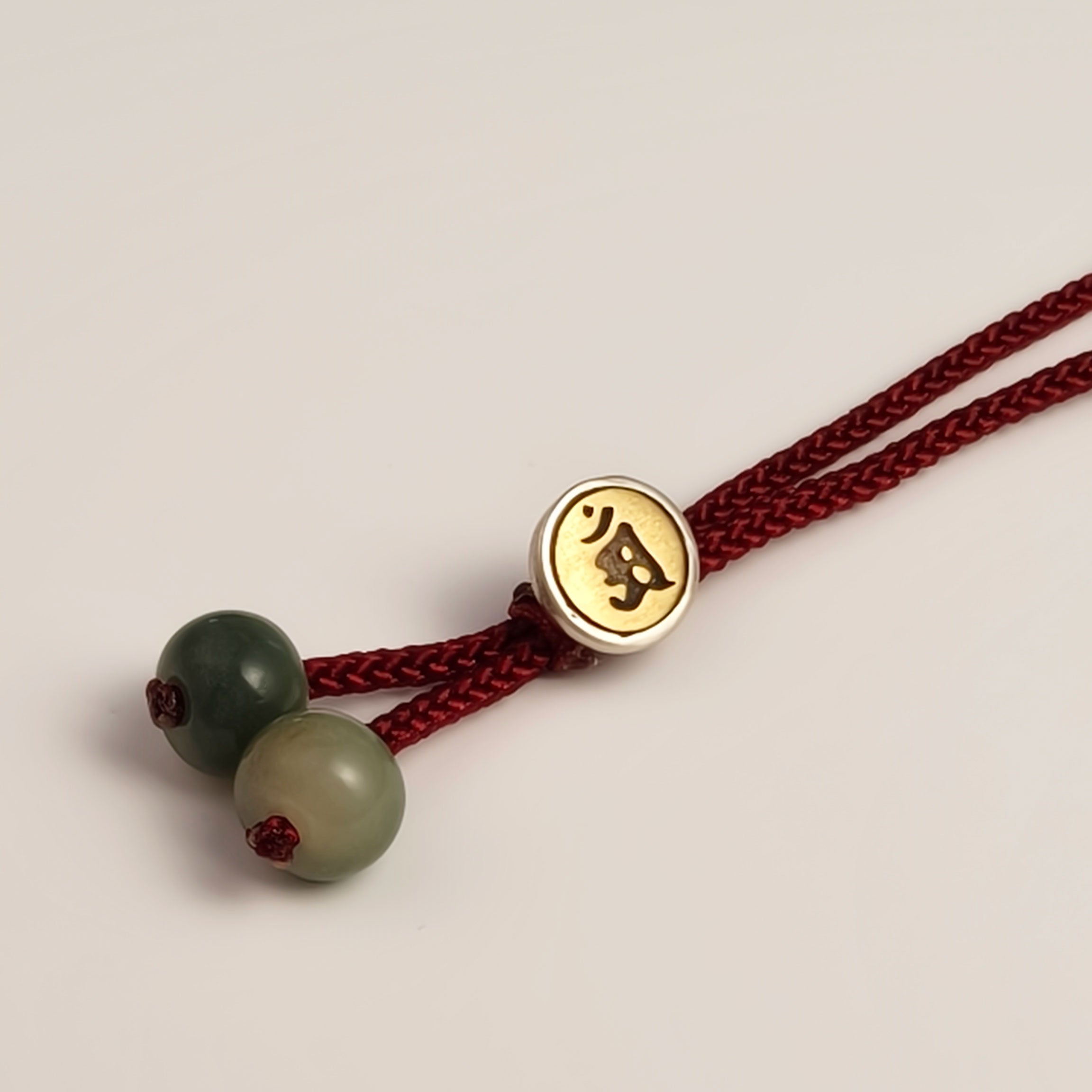 Handwoven red string bracelet with bodhi seed beads, engraved metal clasp